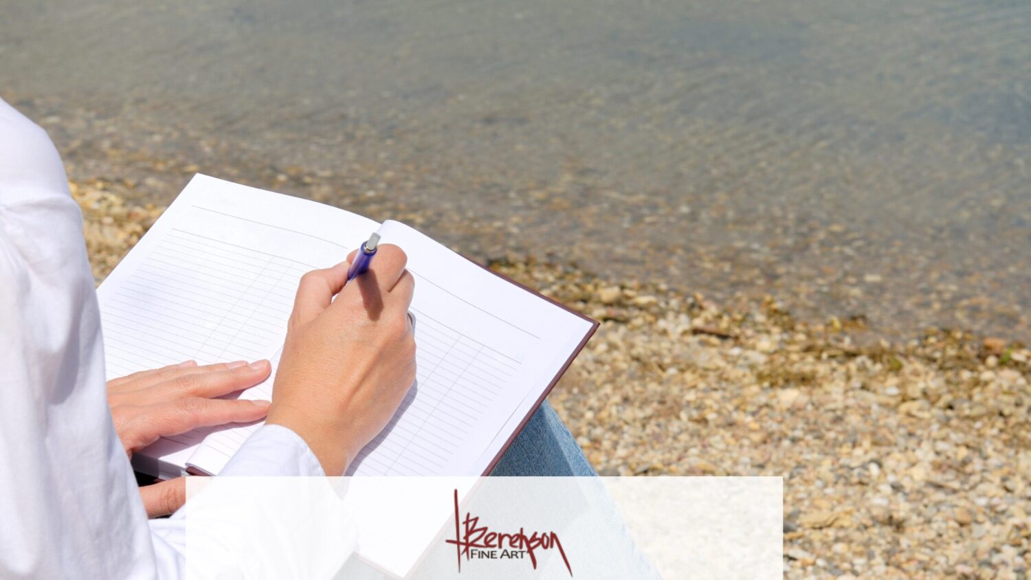 A person in a white shirt writes in a blank, lined notebook by the pebbled shore, embodying the tranquil brush of inspiration. Clear water shimmers in the background, with a "Berenson Fine Art" watermark at the bottom.